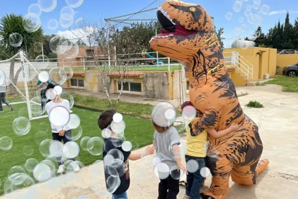 Dinosaurio gigantón jugando con niños